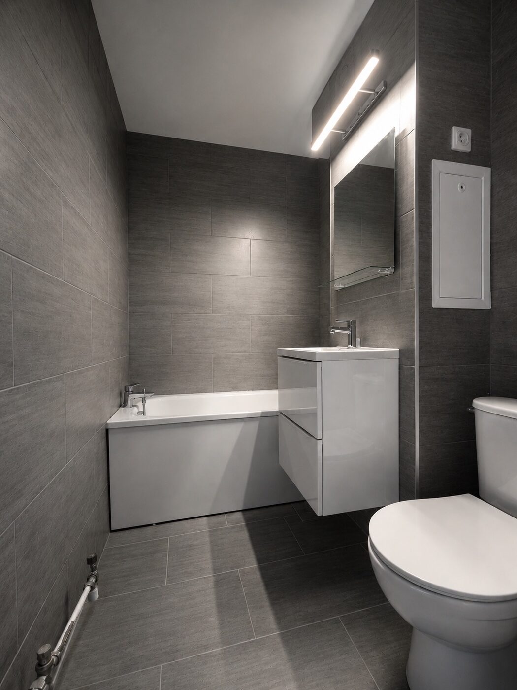 Salle de bain après rénovation complète, carrelage gris et meuble suspendu